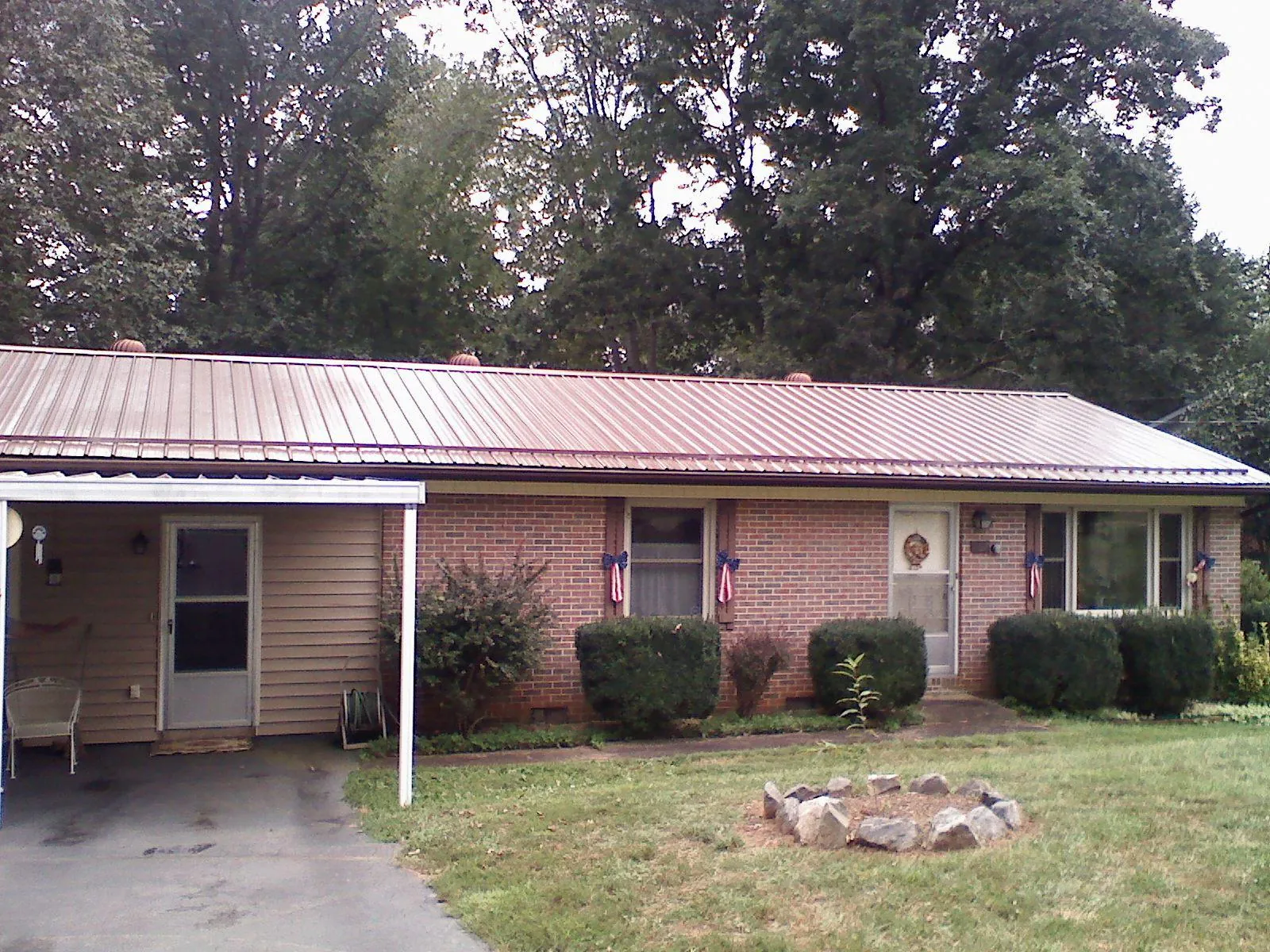 Bronze metal roof and carport on a brick ranch home — Roof Repair work by our crew in Lake Andes